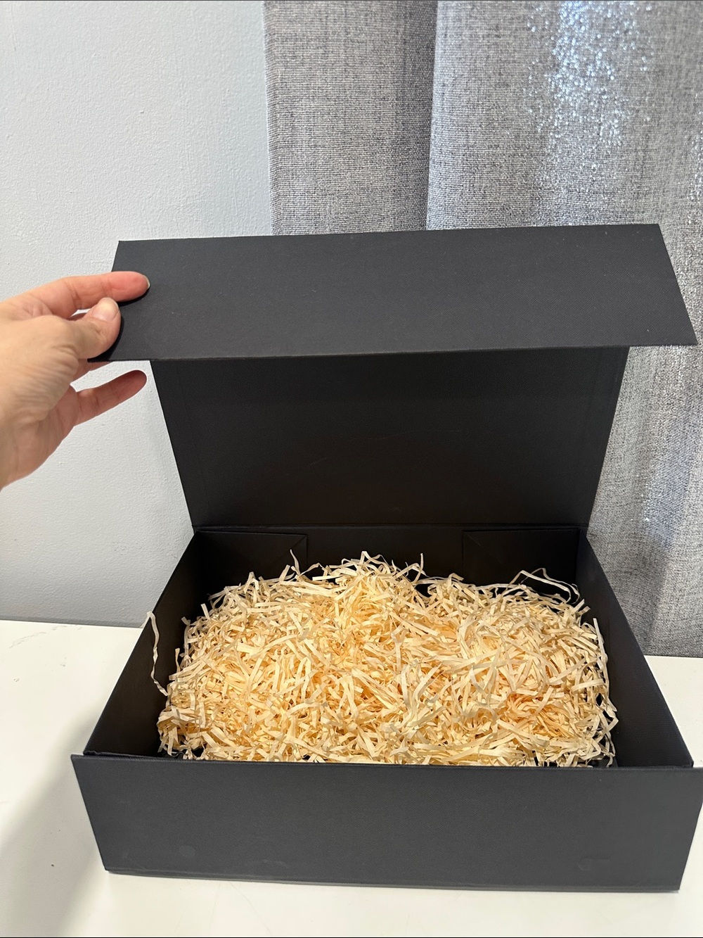 Black Gift Box with Natural Paper Shred Filler and magnetic closure.